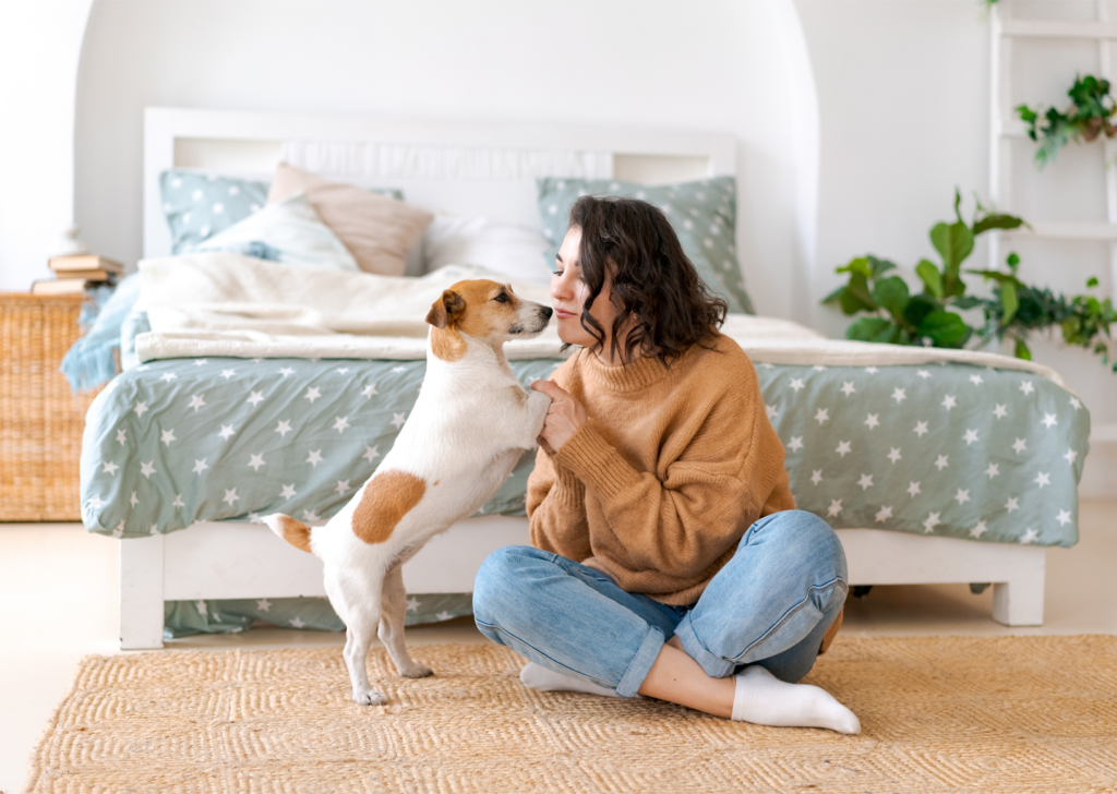 A woman sitting on the floor petting and bonding with her dog